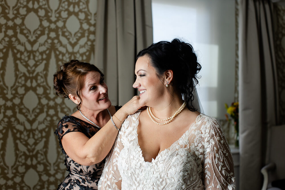 Mother of the bride puts her daughter's necklace on at the Omni William Penn Pittsburgh