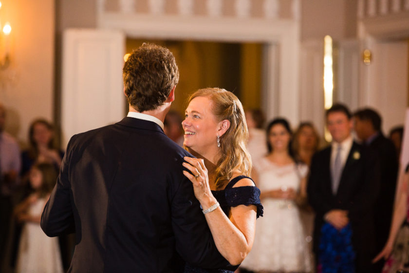 Mother smiling at her son during mother son wedding dance