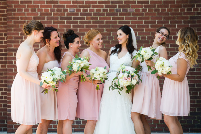 Bride and bridesmaids in mismatched light pink short dresses
