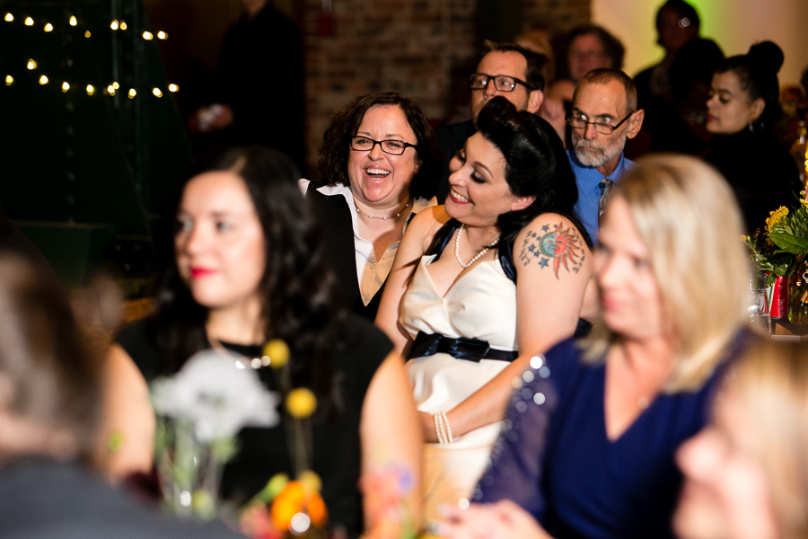 Brides Listening to Reception Speeches and Laughing